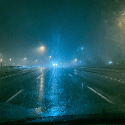 headlights under pale blue rain Front Cover